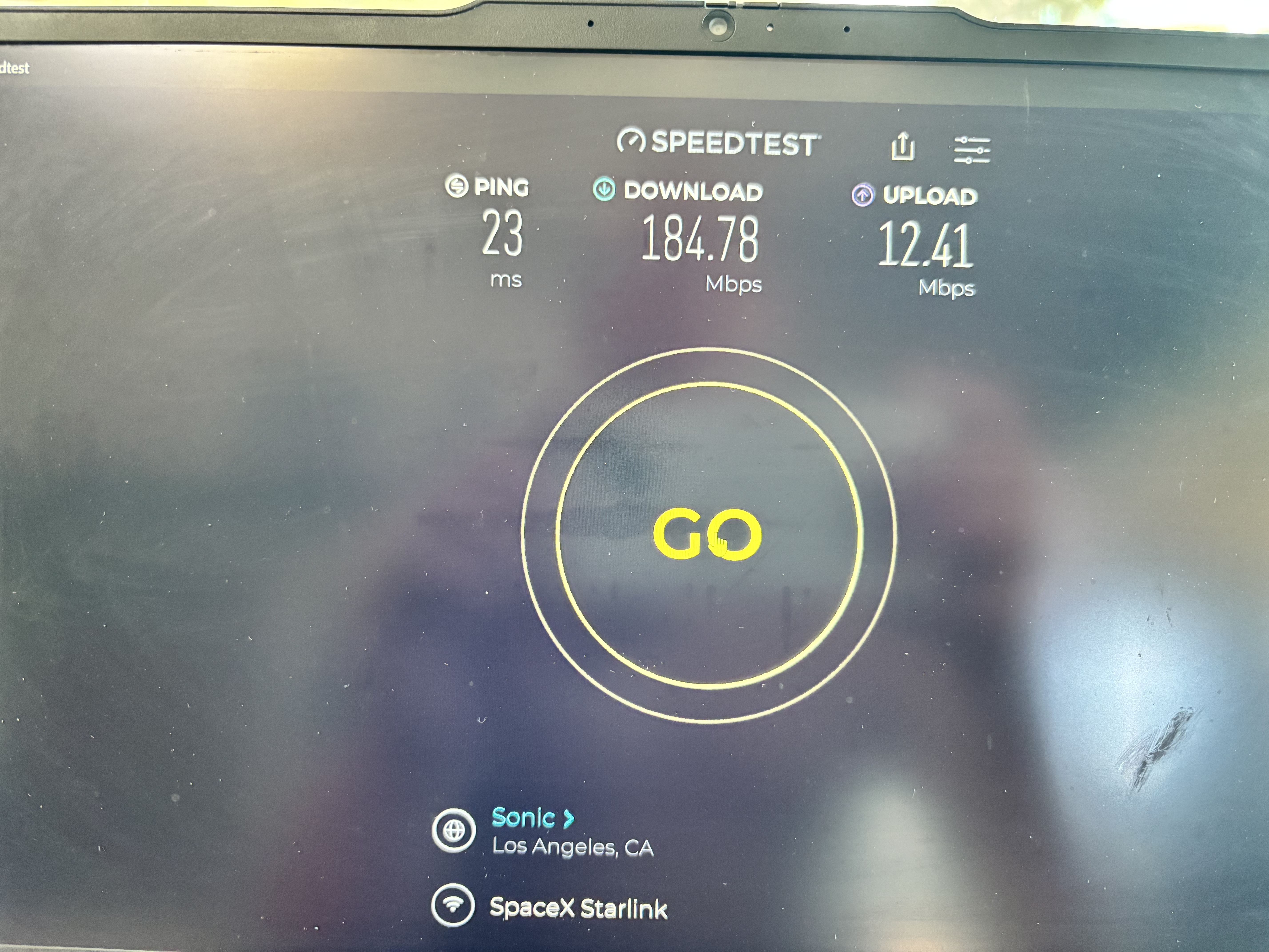 Ookla Speedtest on laptop showing 184.78 Mbps download, 12.41 Mbps upload, and 23 ms ping.